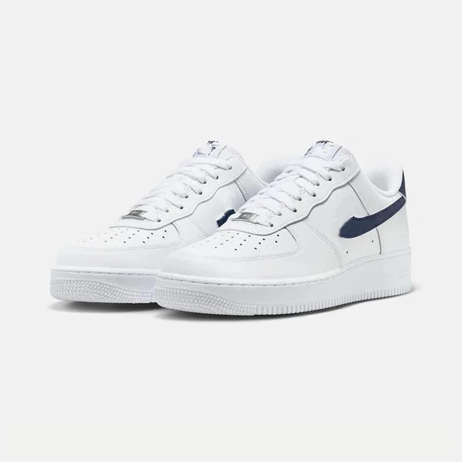 White low-top sneakers with a navy side detail